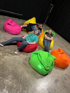 three people in rainbow bean bags