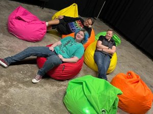 three people in rainbow bean bags